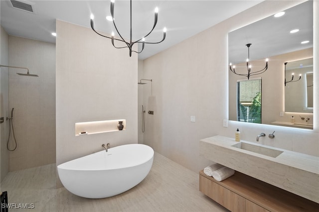 bathroom featuring vanity, a chandelier, and shower with separate bathtub