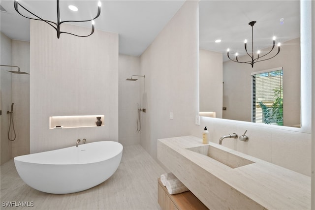 bathroom featuring a notable chandelier, vanity, and separate shower and tub