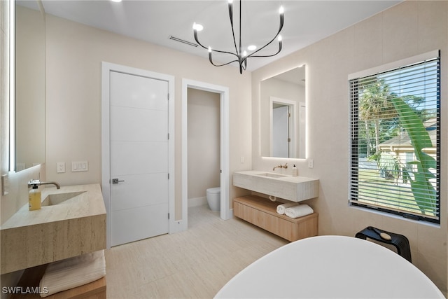 bathroom with vanity, a chandelier, and toilet