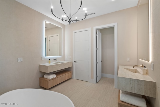 bathroom featuring a notable chandelier, vanity, a bath, and tile walls