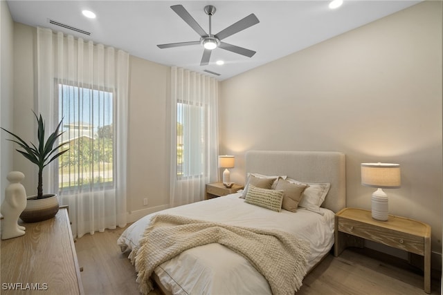 bedroom with light hardwood / wood-style floors and ceiling fan