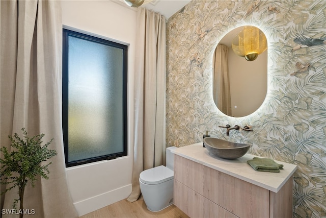 bathroom featuring wood-type flooring, vanity, and toilet