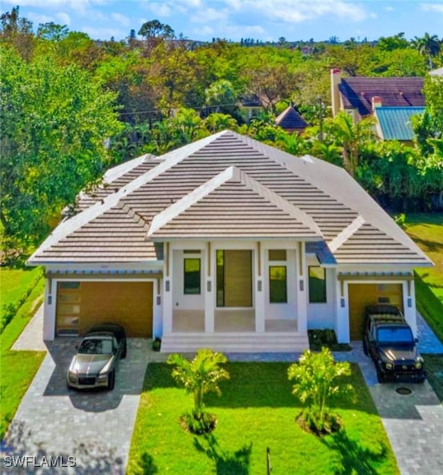 1364 Cypress Woods Dr, Naples, FL 34103 - view of front of house with concrete driveway, an attached garage, a tile roof, and a front lawn
