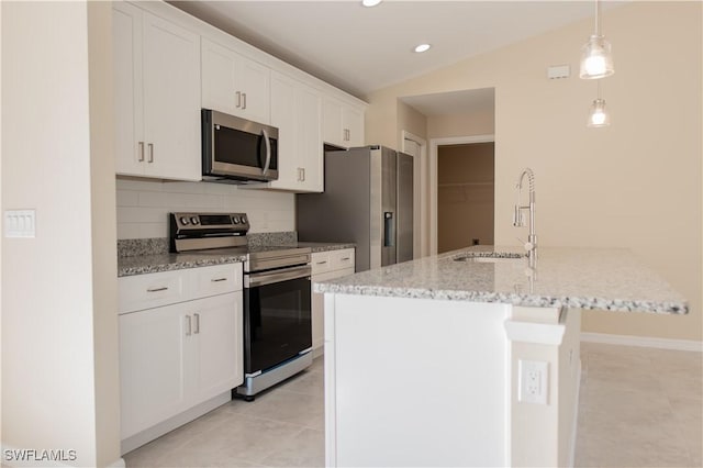 kitchen featuring white cabinets, appliances with stainless steel finishes, a kitchen island with sink, and sink