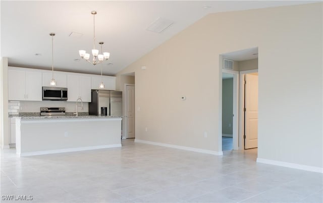 kitchen with stainless steel appliances, white cabinetry, a kitchen island with sink, and lofted ceiling