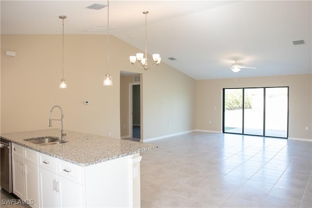 kitchen with light stone counters, ceiling fan with notable chandelier, vaulted ceiling, sink, and white cabinetry