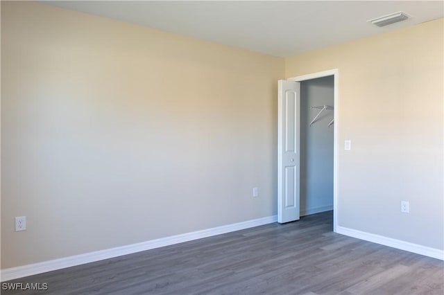 unfurnished bedroom featuring a closet and dark wood-type flooring