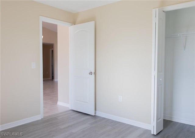 unfurnished bedroom featuring a closet and light hardwood / wood-style flooring