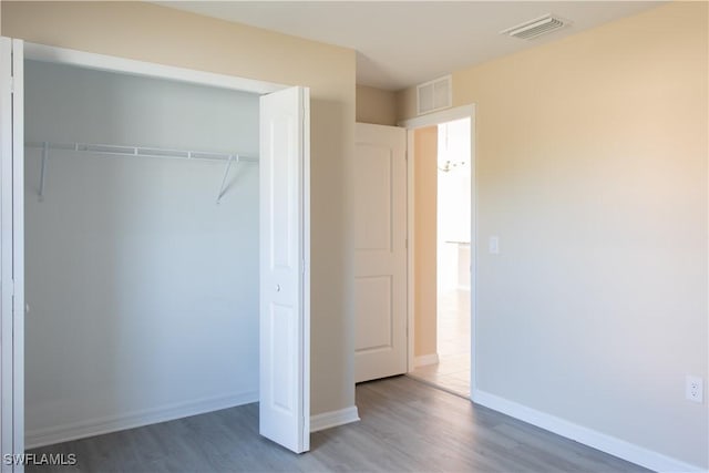 unfurnished bedroom featuring hardwood / wood-style flooring and a closet