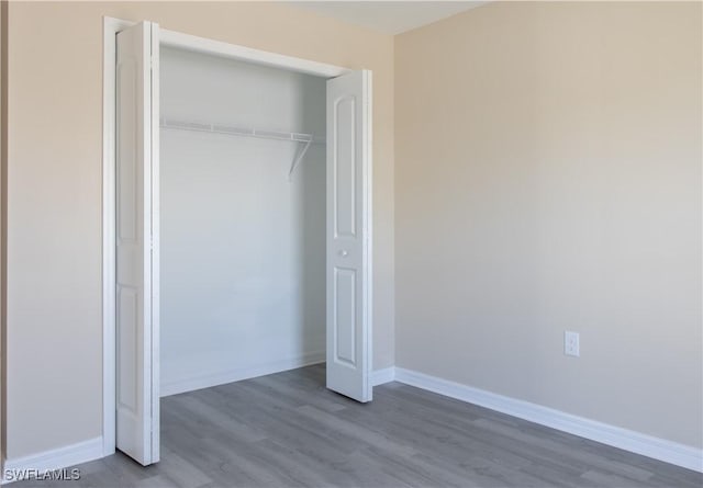 unfurnished bedroom with a closet and wood-type flooring