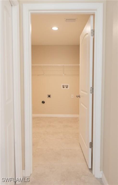 clothes washing area featuring washer hookup, electric dryer hookup, and light tile patterned flooring