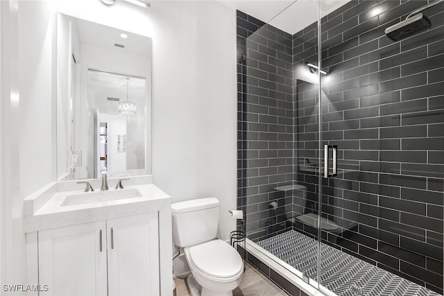 bathroom with vanity, toilet, and a shower with door