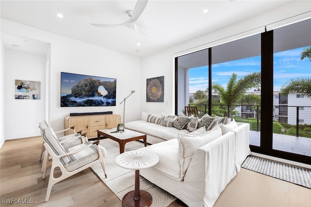 living room with ceiling fan and light hardwood / wood-style floors