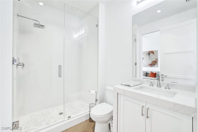 bathroom featuring hardwood / wood-style floors, vanity, an enclosed shower, and toilet