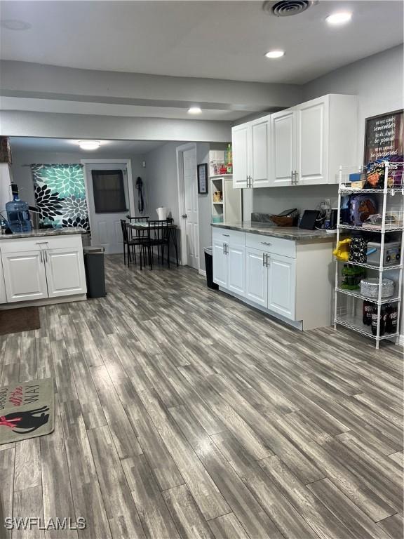 kitchen with white cabinets and light hardwood / wood-style flooring