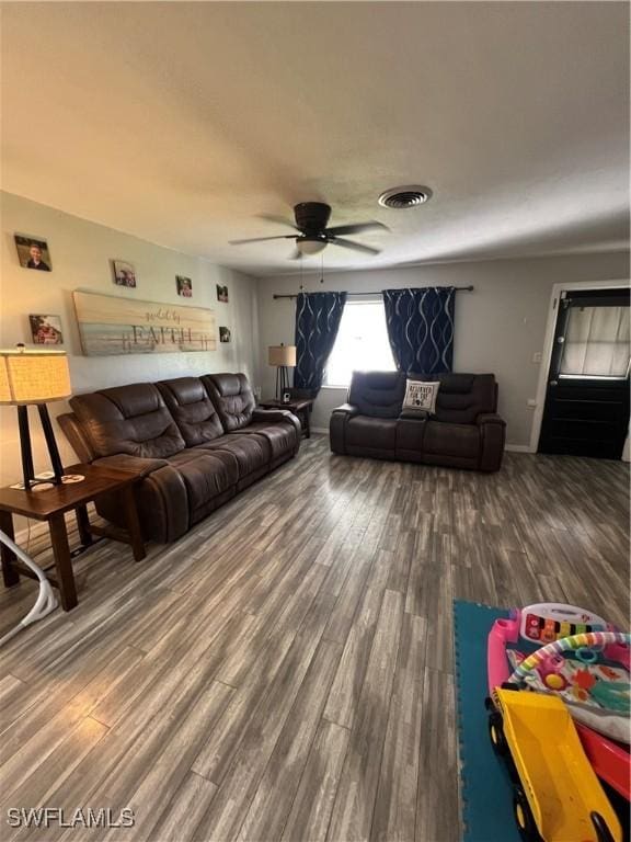 living room featuring hardwood / wood-style floors and ceiling fan