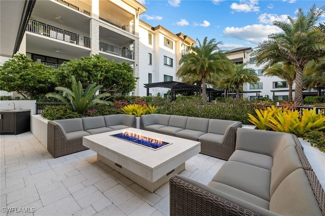 view of community featuring a patio area, a pergola, a sink, and an outdoor living space with a fire pit