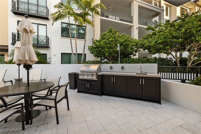 view of patio with outdoor dining area, a sink, a grill, and area for grilling