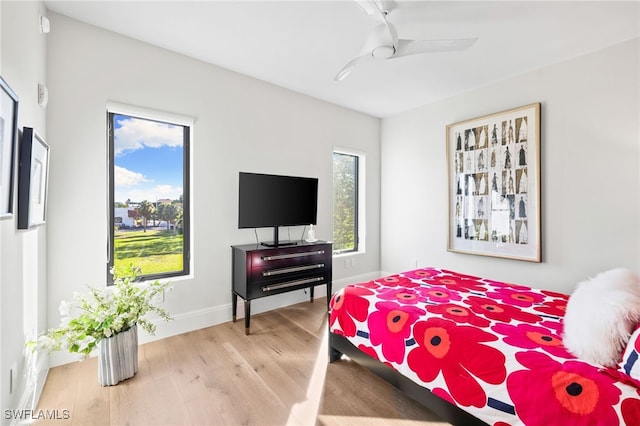 bedroom featuring baseboards, a ceiling fan, and light wood-style floors