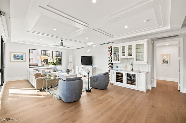 living room with coffered ceiling, visible vents, baseboards, light wood-style floors, and a dry bar