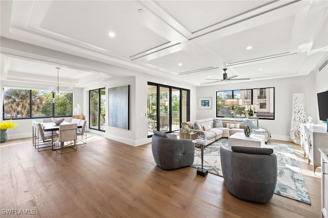 living area featuring recessed lighting, wood finished floors, coffered ceiling, baseboards, and ceiling fan with notable chandelier