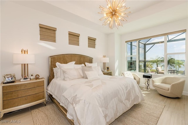 bedroom with a notable chandelier and light hardwood / wood-style flooring