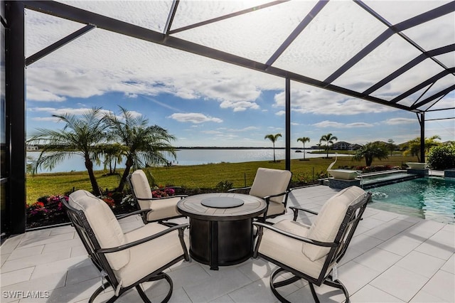 view of patio featuring a water view, a fire pit, and a lanai