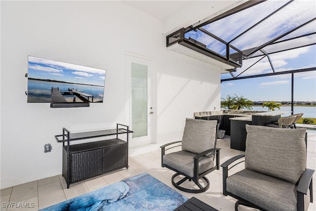 view of patio featuring a lanai and a water view