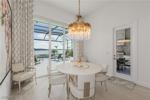 dining space with a water view and an inviting chandelier