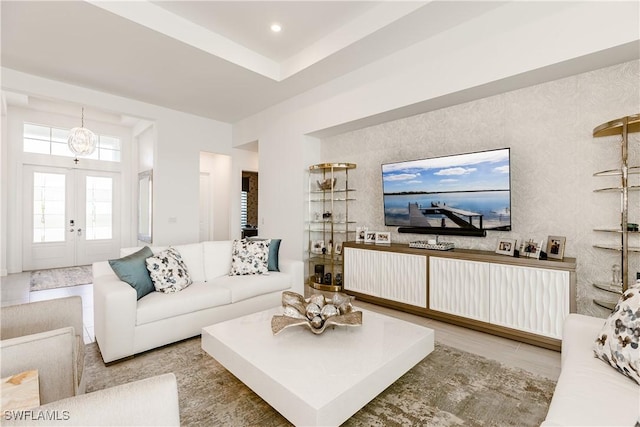 living room featuring french doors and a chandelier