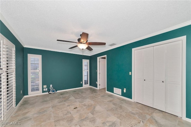 unfurnished bedroom featuring ceiling fan, a closet, a textured ceiling, and ornamental molding