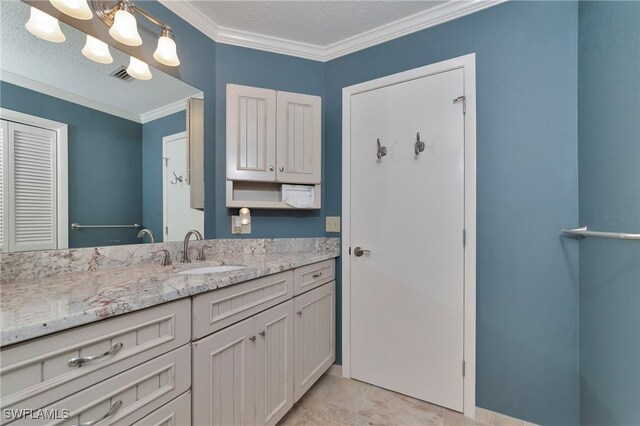 bathroom with a textured ceiling, vanity, crown molding, and tile patterned floors