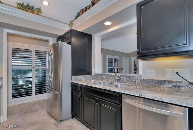 kitchen featuring sink, light stone counters, crown molding, vaulted ceiling, and appliances with stainless steel finishes