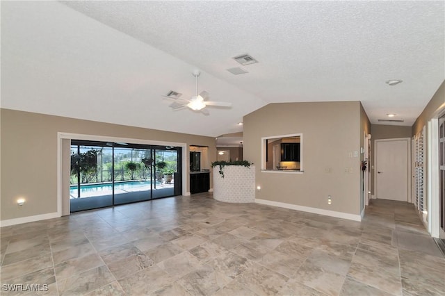 unfurnished living room with a textured ceiling, vaulted ceiling, and ceiling fan