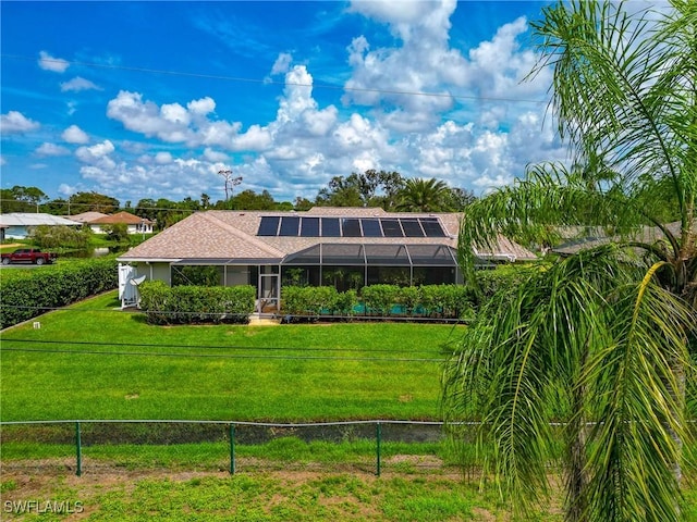 view of front facade with a front yard and glass enclosure