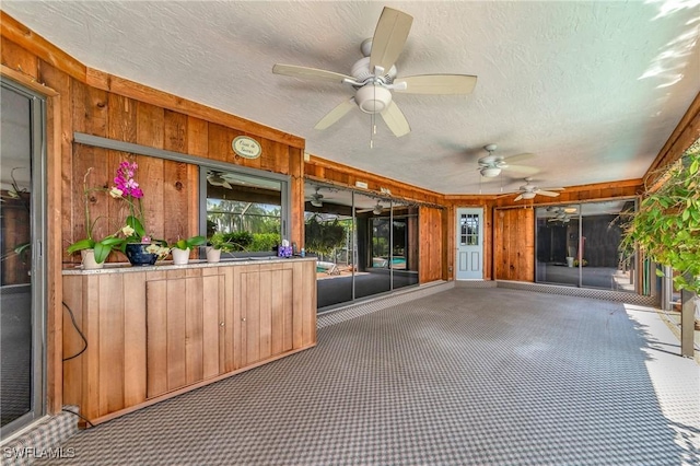 unfurnished sunroom featuring ceiling fan