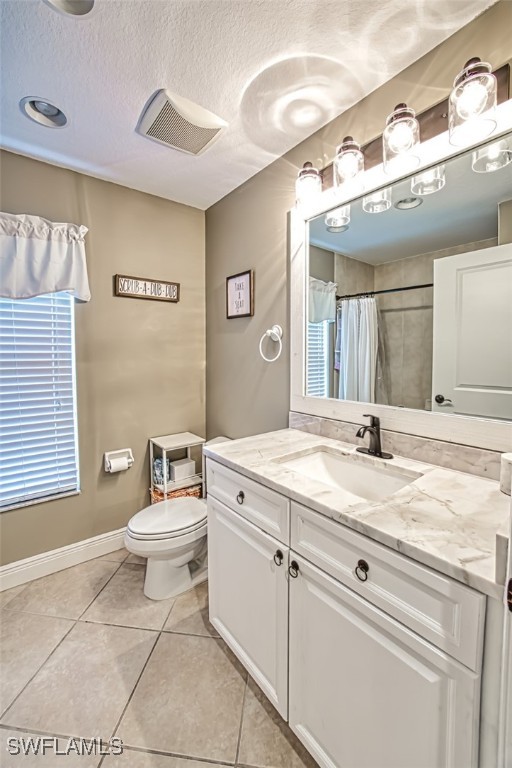 bathroom with a shower with shower curtain, toilet, tile patterned flooring, a textured ceiling, and vanity