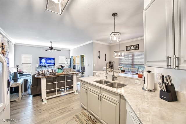 kitchen with open floor plan, ornamental molding, a sink, and decorative light fixtures