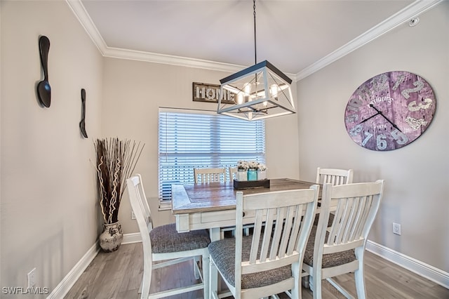 dining space with ornamental molding, baseboards, and wood finished floors