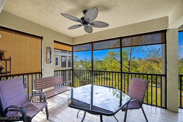 sunroom / solarium featuring a ceiling fan and a wealth of natural light