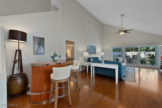 living room featuring dark hardwood / wood-style flooring, high vaulted ceiling, and ceiling fan