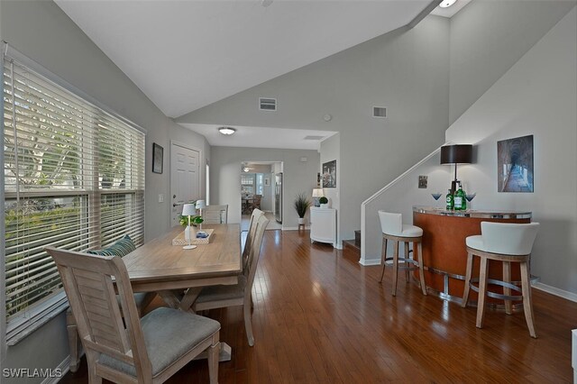 dining area featuring lofted ceiling and dark wood-type flooring