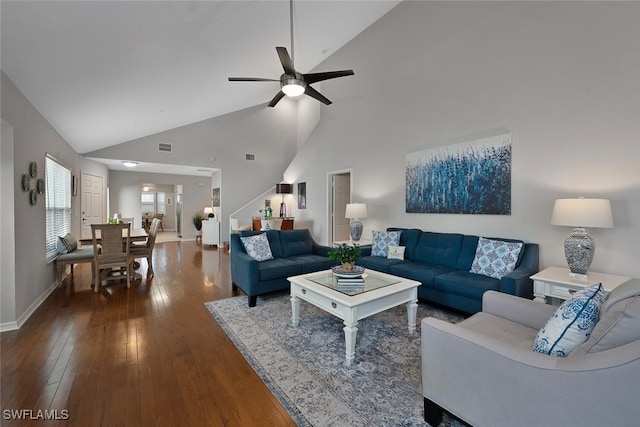 living room with visible vents, high vaulted ceiling, dark wood finished floors, baseboards, and ceiling fan