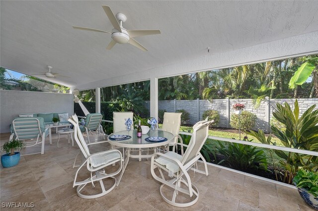 sunroom featuring lofted ceiling and ceiling fan