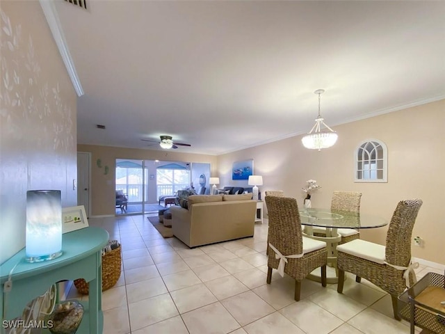 tiled dining space featuring ceiling fan and ornamental molding