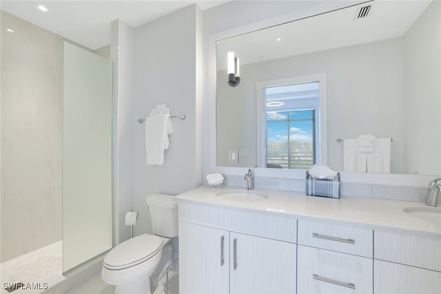 bathroom featuring vanity, toilet, and a shower