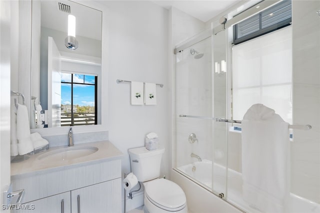 full bathroom with vanity, toilet, and bath / shower combo with glass door