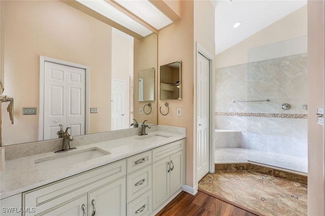 bathroom with hardwood / wood-style floors, vanity, and lofted ceiling