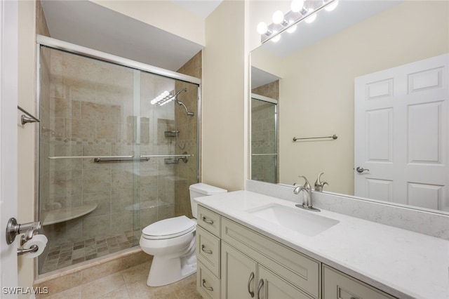 bathroom featuring tile patterned flooring, vanity, toilet, and a shower with shower door