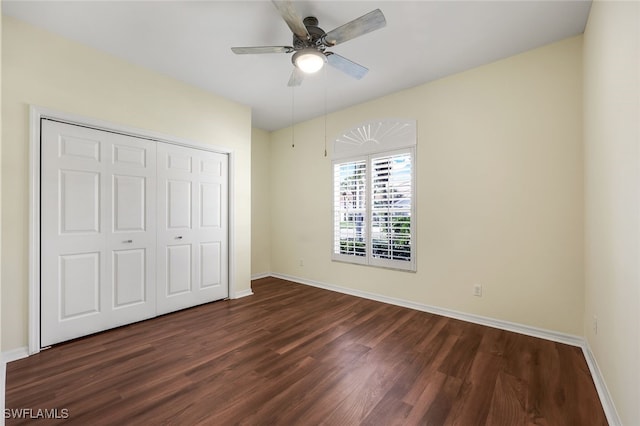 unfurnished bedroom featuring ceiling fan, dark wood-type flooring, and a closet